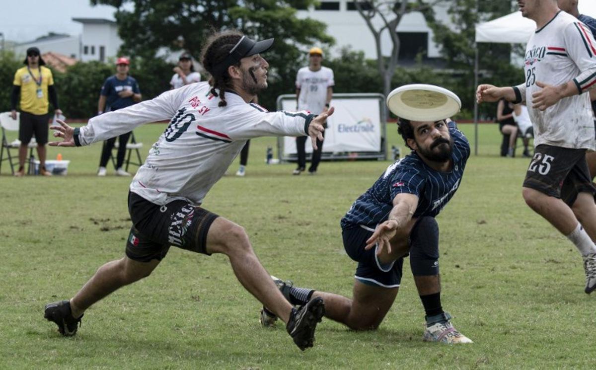 Mexico's Victor Bautista (L) and Dominican Republic's Alejandro Machado vie for the frisbee during the final of the Central American and Caribbean Ultimate 2024 Tournament between Mexico and the Dominican Republic in San Jose on July 21, 2024.  Ezequiel BECERRA / AFP