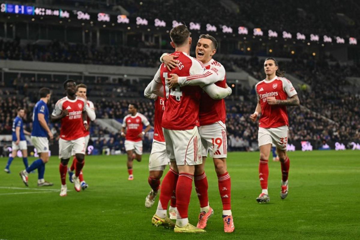 Arsenal's Belgian midfielder #19 Leandro Trossard (R) embraces Arsenal's Swedish striker #14 Viktor Gyokeres (L) as Gyokeres celebrates scoring the opening goal to take the lead 0-1 during the English Premier League football match between Everton and Arsenal at Hill Dickinson Stadium in Liverpool, north west England on December 20, 2025.  Oli SCARFF / AFP