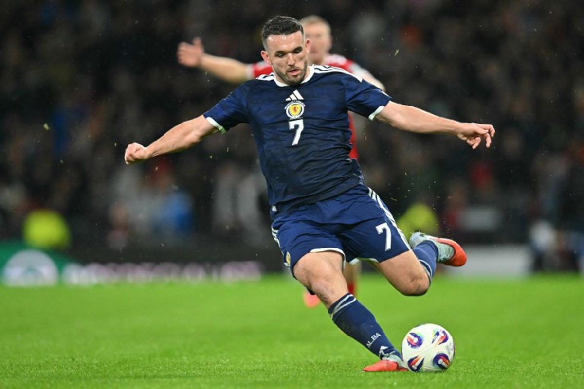 Scotland's midfielder #07 John McGinn crosses the ball during the FIFA World Cup 2026 European qualification football match between Scotland and Denmark at Hampden Park in Glasgow on November 18, 2025.     ANDY BUCHANAN / AFP