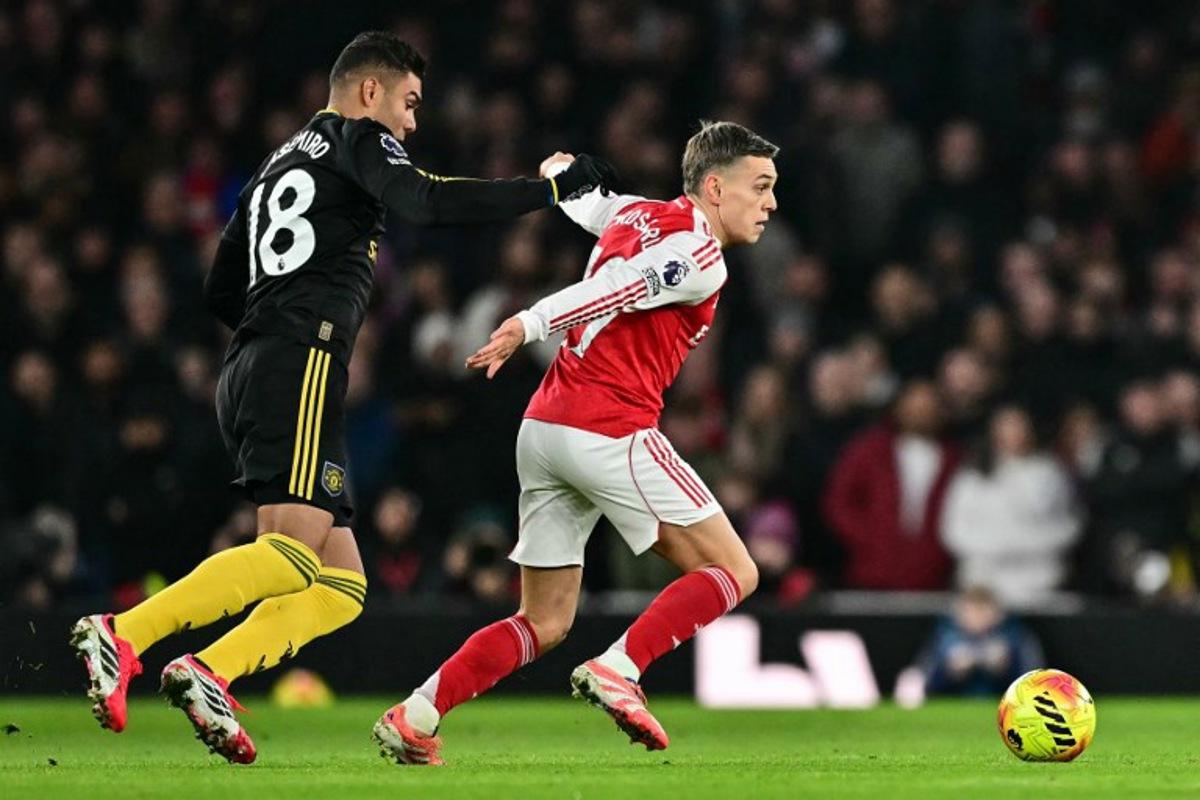 Manchester United's Brazilian midfielder #18 Casemiro (L) tackles Arsenal's Belgian midfielder #19 Leandro Trossard (R) for a free kick during the English Premier League football match between Arsenal and Manchester United at the Emirates Stadium in London on January 25, 2026.   Ben STANSALL / AFP