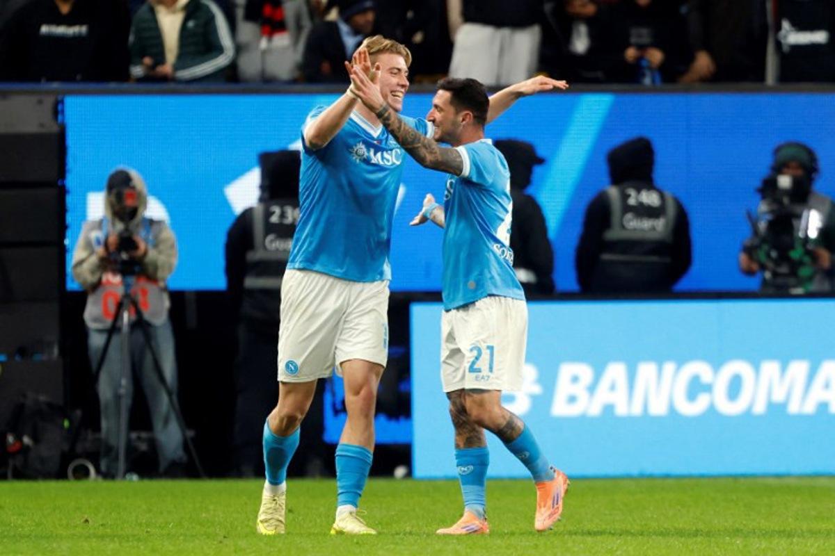 SCC Napoli Rasmus Hojlund (L) celebrates with teammate Matteo Politano after scoring the second goal during the Italian Super Cup semi-final match between SCC Napoli and AC Milan at King Saud University Stadium in Riyadh on December 18, 2025.  Fayez Nureldine / AFP