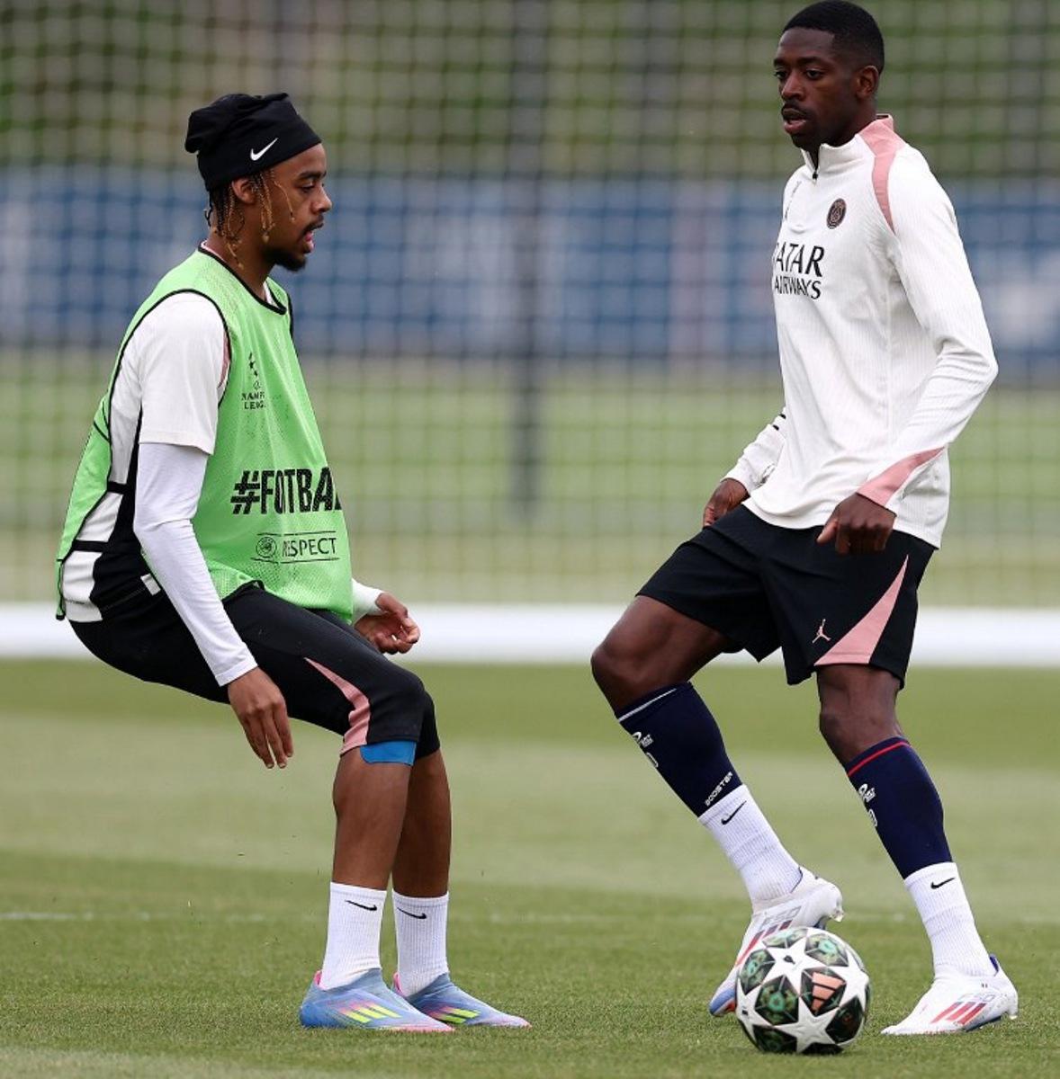 Paris Saint-Germain's French forward #29 Bradley Barcola (L) and Paris Saint-Germain's French forward #10 Ousmane Dembele (R) attend a training session ahead of the UEFA Champions League final football match at the club training camp in Poissy, west of Paris, on May 21, 2025. PSG will play the French Cup final football match against Stade de Reims on May 24, 2025 and Champions League's against Inter Milan on May 31, 2025. FRANCK FIFE / AFP