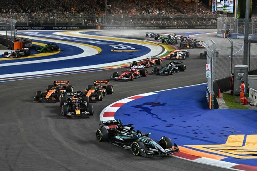 Mercedes' British driver George Russell leads ahead of Red Bull Racing's Dutch driver Max Verstappen at the start of the Formula One Singapore Grand Prix night race at the Marina Bay Street Circuit in Singapore on October 5, 2025.  MOHD RASFAN / AFP