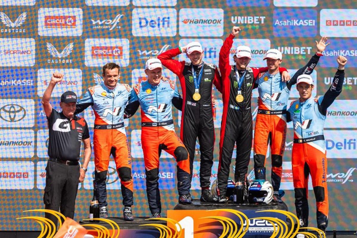 Winners Swedish Oliver Solberg (C-R) and his British co-driver Elliott Edmondson (C-L), second placed Estonian driver Ott Tanak (3rd L) and co-driver Martin Jarveoja (2nd L) and third placed Belgium driver Thierry Neuville (R) and co-driver Martijn Wydaeghe (2nd R) celebrate on the podium after winning the Rally Estonia, the eighth round of the FIA World Rally Championship, on July 20, 2025 in Kaariku, Estonia.  TIMO ANIS / AFP