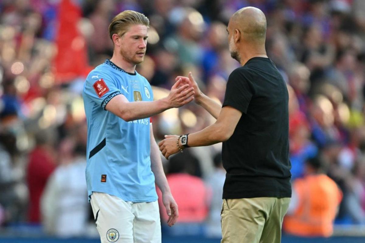 Manchester City's Spanish manager Pep Guardiola (R) shakes hands with Manchester City's Belgian midfielder #17 Kevin De Bruyne (L) on the pitch after the English FA Cup final football match between Crystal Palace and Manchester City at Wembley stadium in London, on May 17, 2025. Crystal Palace beat Manchester City 1-0 in the FA Cup final at Wembley on Saturday to win the first major trophy in the club's history. Glyn KIRK / AFP