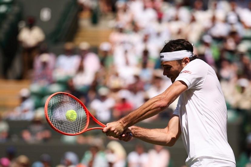 US player Taylor Fritz plays a backhand return to Russia's Karen Khachanov during their men's singles quarter-final tennis match on the ninth day of the 2025 Wimbledon Championships at The All England Lawn Tennis and Croquet Club in Wimbledon, southwest London, on July 8, 2025.  HENRY NICHOLLS / AFP