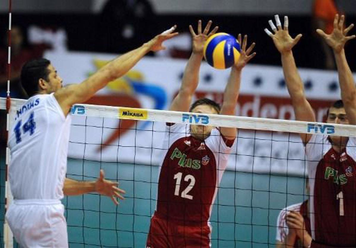 Venezuela's Ereu Thomas (L) spikes the ball over Poland's Woicki Pawel (C) and Nowakowski Piotr (R) during their Volleyball World League game in La Guaira, Caracas on June 19, 2009. AFP   PHOTO/Juan BARRETO