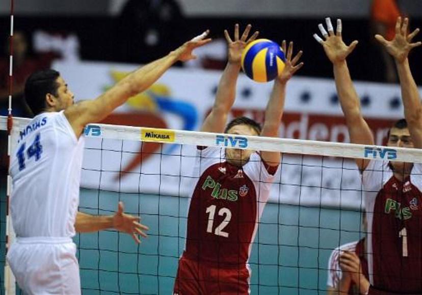Venezuela's Ereu Thomas (L) spikes the ball over Poland's Woicki Pawel (C) and Nowakowski Piotr (R) during their Volleyball World League game in La Guaira, Caracas on June 19, 2009. AFP   PHOTO/Juan BARRETO