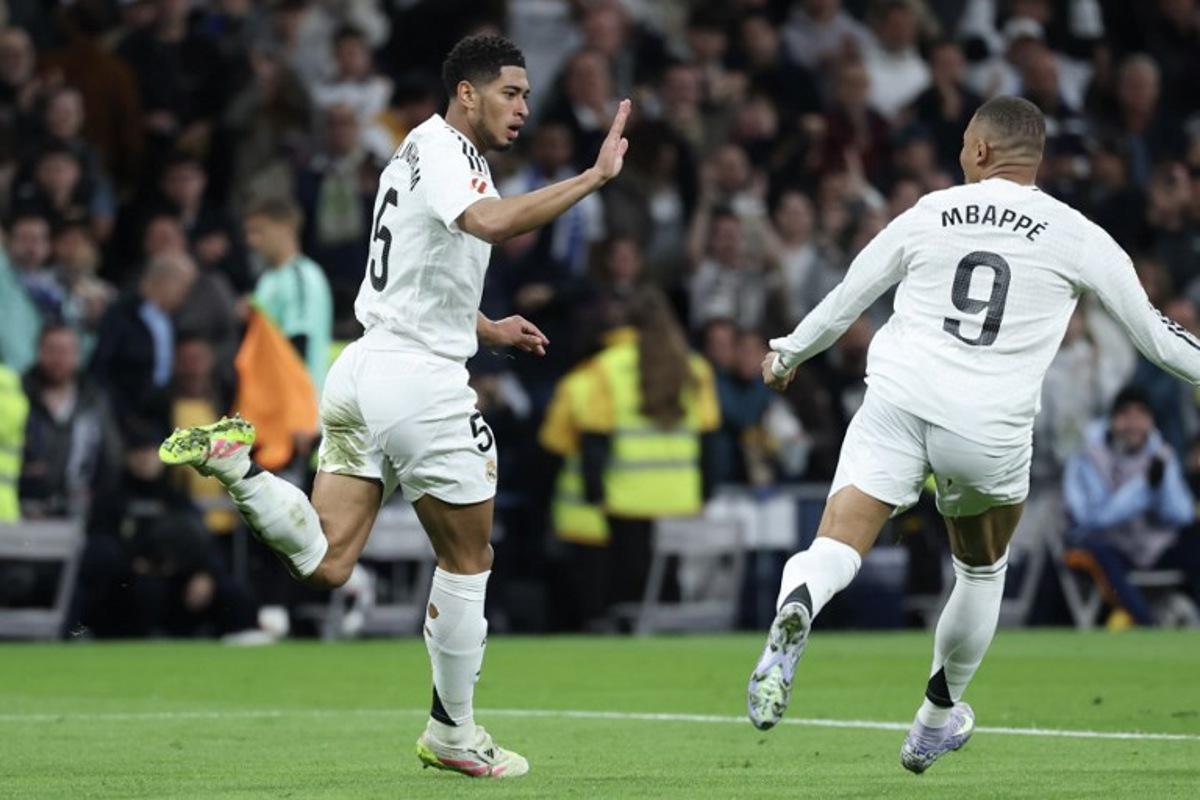 Real Madrid's English midfielder #05 Jude Bellingham (L) celebrates scoring their second goal with Real Madrid's French forward #09 Kylian Mbappe during the Spanish league football match between Real Madrid CF and Club Deportivo Leganes SAD at the Santiago Bernabeu stadium in Madrid on March 29, 2025.  Thomas COEX / AFP