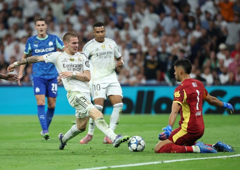Real Madrid's Argentine forward #30 Franco Mastantuono challenges Marseille's Argentine goalkeeper #01 Geronimo Rulli during the UEFA Champions League first round day 1 football match between Real Madrid CF and Olympique de Marseille at the Santiago Bernabeu stadium in Madrid on September 16, 2025.  Pierre-Philippe MARCOU / AFP