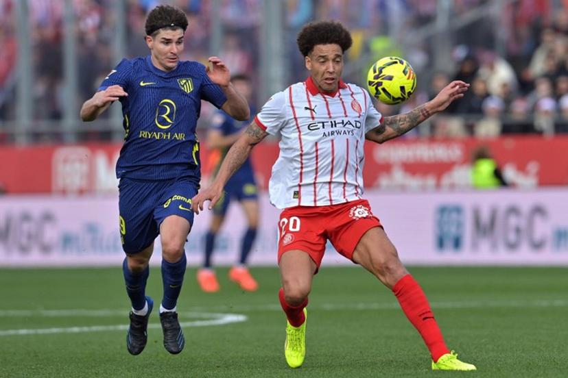 Atletico Madrid's Argentine forward #19 Julian Alvarez (L) and Girona's Belgian defender #20 Axel Witsel fight for the ball during the Spanish league football match between Girona FC and Club Atletico de Madrid at Montilivi Stadium in Girona on December 21, 2025.  MANAURE QUINTERO / AFP