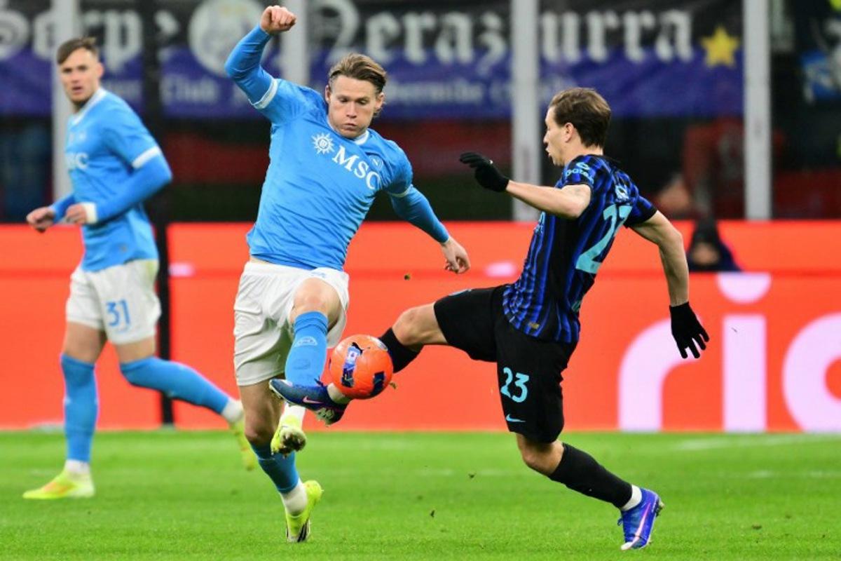 Napoli's Scottish midfielder #08 Scott McTominay (L) fights for the ball with Inter Milan's Italian midfielder #23 Nicolo Barella during the Italian Serie A football match between Inter Milan and Napoli at San Siro stadium in Milan, on January 11, 2026.  Stefano RELLANDINI / AFP