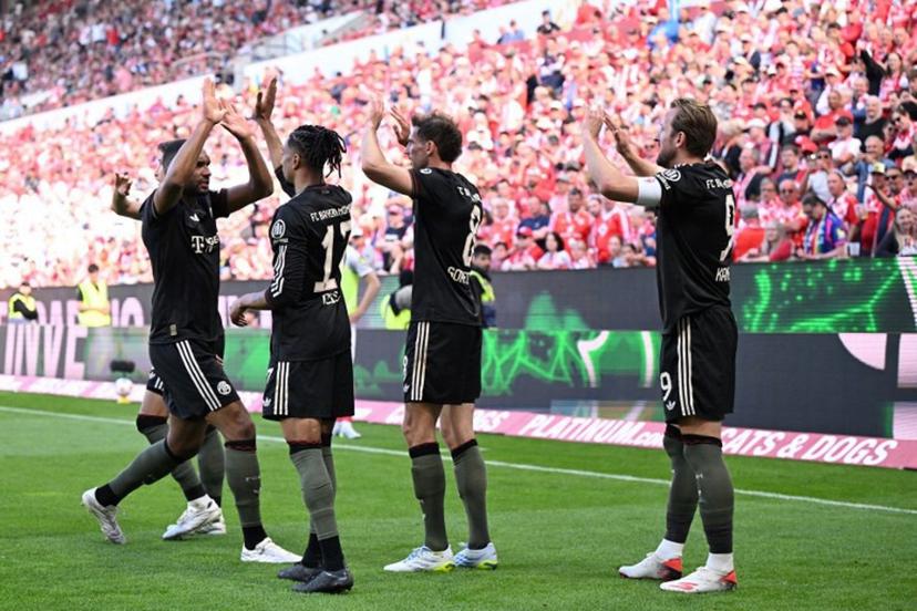 Bayern Munich's English forward #09 Harry Kane celebrates with team mates after scoring his team's fourth goal 3:4 during the German first division Bundesliga football match between 1 FSV Mainz 05 and FC Bayern Munich in Mainz, western Germany on April 25, 2026.  Kirill KUDRYAVTSEV / AFP