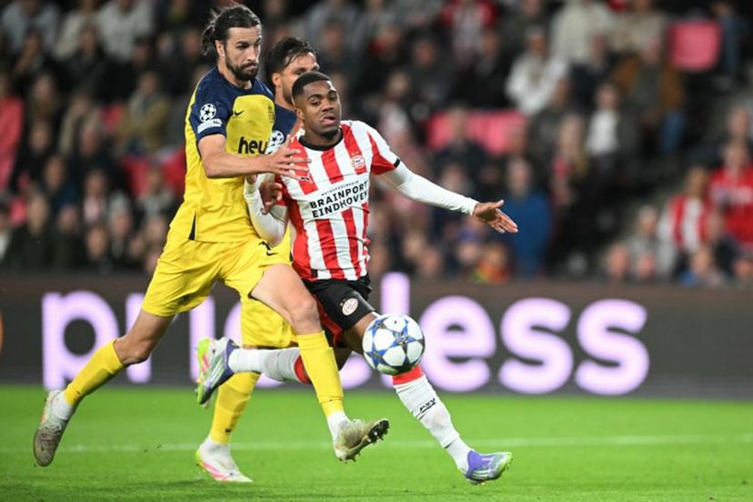 PSV Eindhoven's Dutch forward #21 Myron Boadu (R) and Union's English defender #16 Christian Burgess fight for the ball during the UEFA Champions League first round day 1 football match between PSV Eindhoven and Union Saint-Gilloise at the Philips Stadium, in Eindhoven on September 16, 2025.   NICOLAS TUCAT / AFP