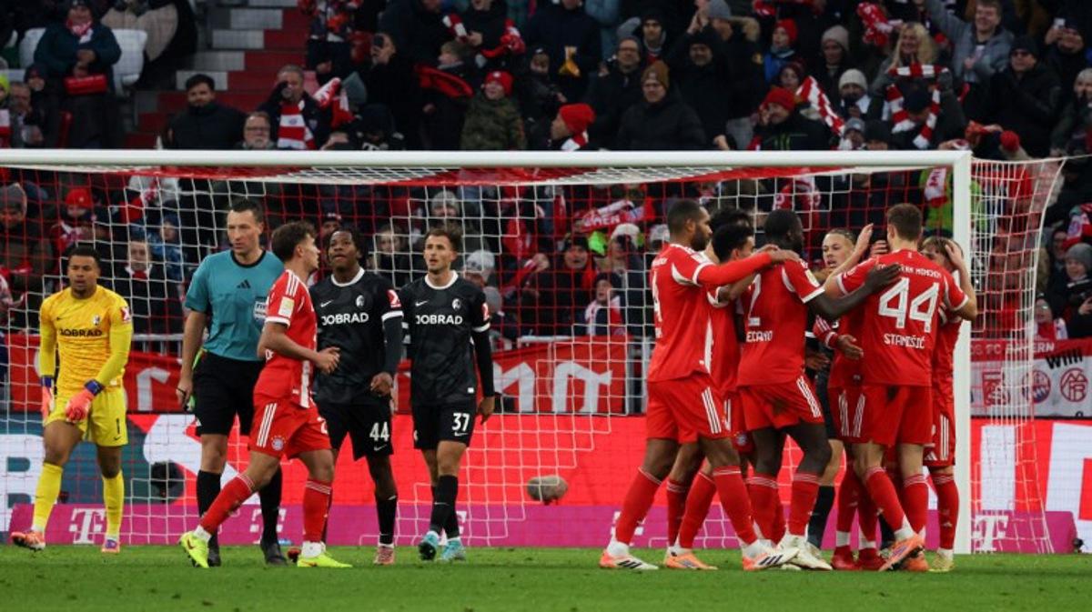 Bayern Munich's players celebrate scoring their team's second goal scored by Bayern Munich's French midfielder #17 Michael Olise during the German first division Bundesliga football match between FC Bayern Munich and SC Freiburg in Munich, southern Germany on November 22, 2025.  Karl-Josef HILDENBRAND / AFP