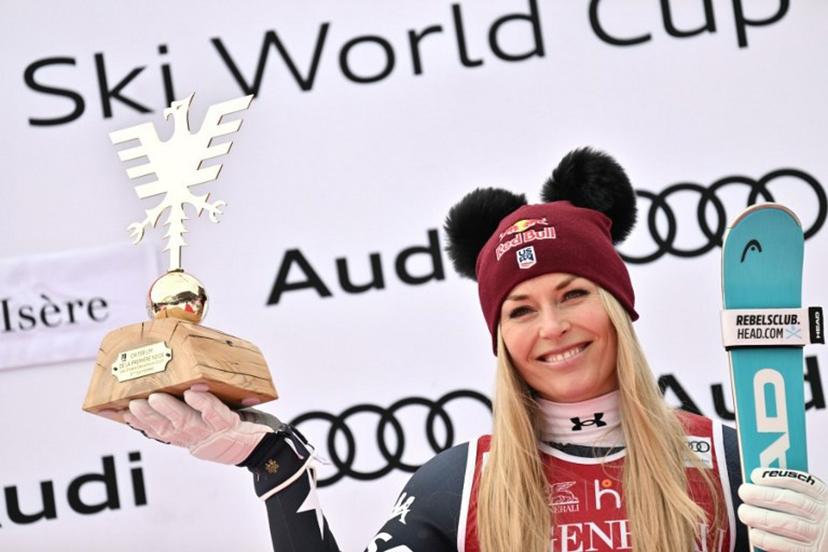 Third-placed US Lindsey Vonn holds her trophy as she celebrates on the podium of the women's Super G event during the FIS Alpine Ski World Cup 2025-2026, in Val d'Isere, southwestern France, on December 21, 2025.  Jeff PACHOUD / AFP