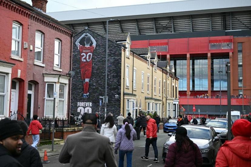 Arriving fans pass a mural created by artist Murwalls, dedicated to Liverpool's late Portugese footballer Diogo Jota who died in a car crash in July, ahead of the English Premier League football match between Liverpool and Wolverhampton Wanderers at Anfield in Liverpool, north west England on December 27, 2025. Father of three Jota, who married his long-term partner Rute Cardoso 11 days before the accident, died alongside his brother after a Lamborghini they were travelling in came off the road and burst into flames in northern Spain in July. Oli SCARFF / AFP