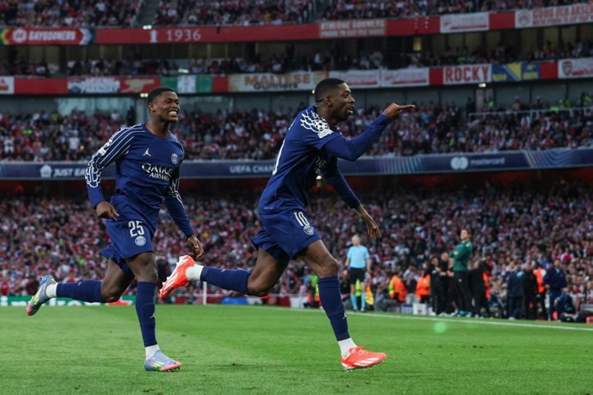 Paris Saint-Germain's French forward #10 Ousmane Dembele (R) celebrates after scoring his team first goal during the UEFA Champions League Semi-final First Leg football match between Arsenal and Paris Saint-Germain (PSG) at the Emirates Stadium in north London, on April 29, 2025.  Adrian Dennis / AFP
