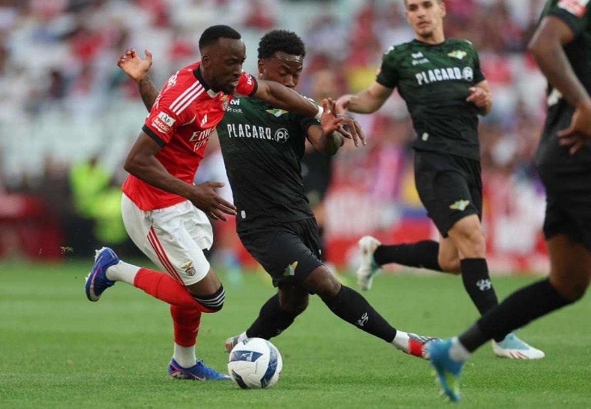 SL Benfica's Belgian forward #11 Dodi Lukebakio fights for the ball with Moreirense's English midfielder #23 Nile John during the Portuguese League football match between SL Benfica and Moreirense FC at Luz Stadium in Lisbon on April 25 , 2026.  PATRICIA DE MELO MOREIRA / AFP