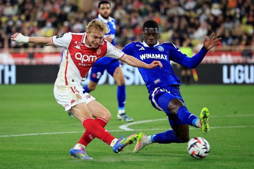 Monaco's Danish forward #14 Mika Biereth (L) shoots towards goal under pressure from Strasbourg's French defender #23 Mamadou Sarr (R) during the French L1 football match between AS Monaco and RC Strasbourg Alsace at the Louis II Stadium (Stade Louis II) in the Principality of Monaco on April 19, 2025.  Valery HACHE / AFP