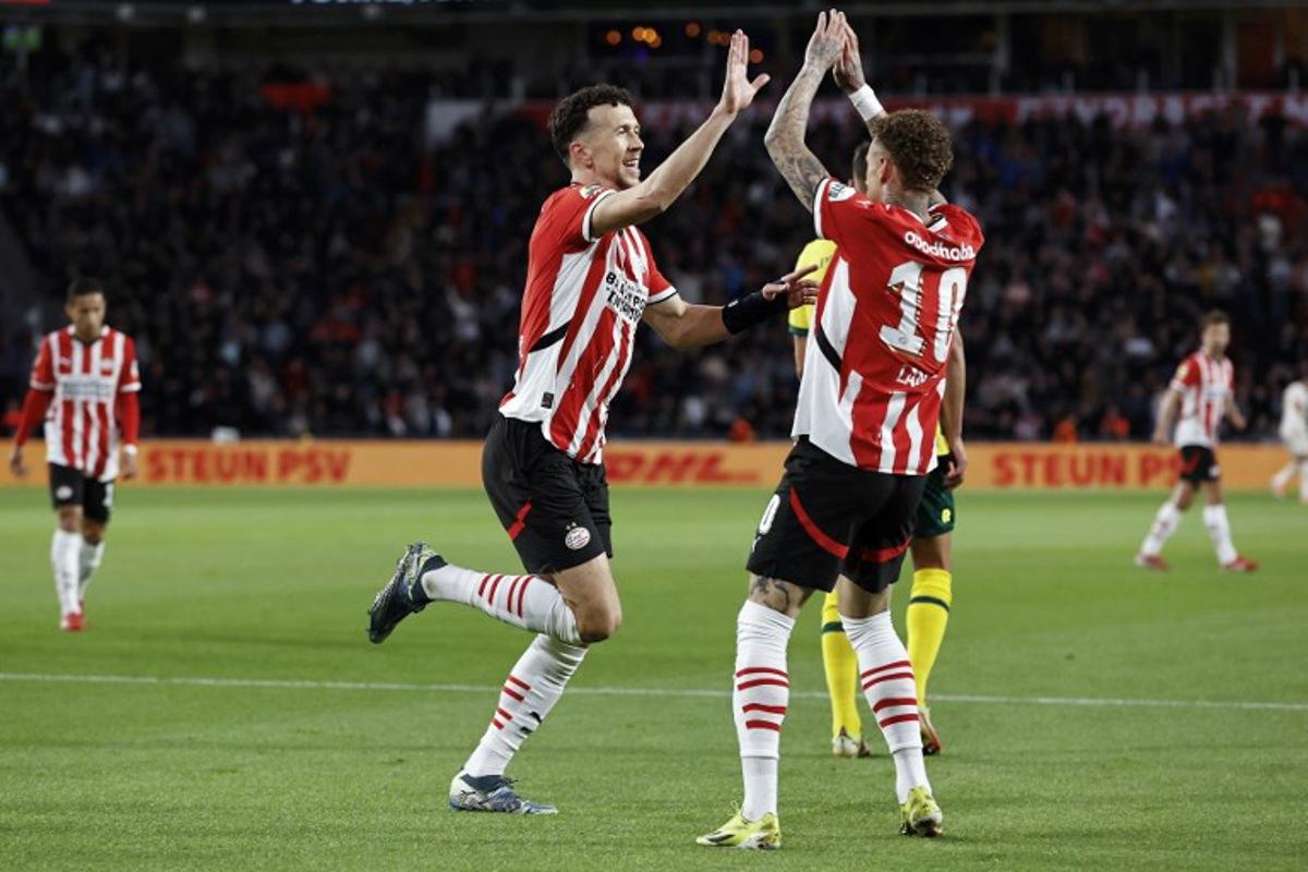 PSV Eindhoven's Croatian #5 defender Ivan Perisic (L) celebrates with his teammate PSV Eindhoven's Dutch forward #10 Noa Lang after scoring his team's second goal during the Dutch Eredivisie football match between PSV Eindhoven and SC Heerenveen at Philips Stadion in Eindhoven on March 8, 2025.  MAURICE VAN STEEN / ANP / AFP