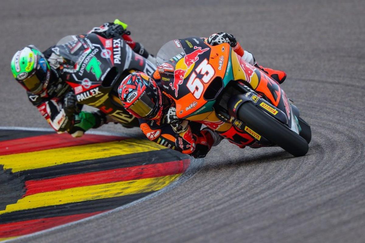 Red Bull KTM Ajo Team's Turkish Moto2 rider Deniz Oncu (R) leads next to Fantic Racing Team's Belgiums Moto2 rider Barry Baltus during the German Moto2 Grand Prix at the Sachsenring racing circuit, in Hohenstein-Ernstthal near Chemnitz, eastern Germany on July 13, 2025.  Ronny Hartmann / AFP