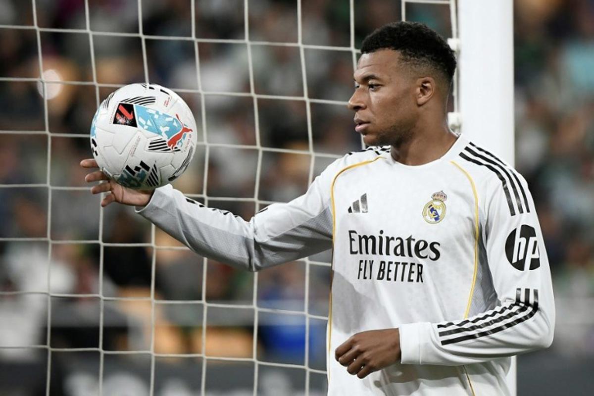 Real Madrid's French forward #10 Kylian Mbappe handles the ball during the Spanish league football match between Real Betis and Real Madrid CF at the La Cartuja stadium in Seville on April 24 , 2026.  CRISTINA QUICLER / AFP