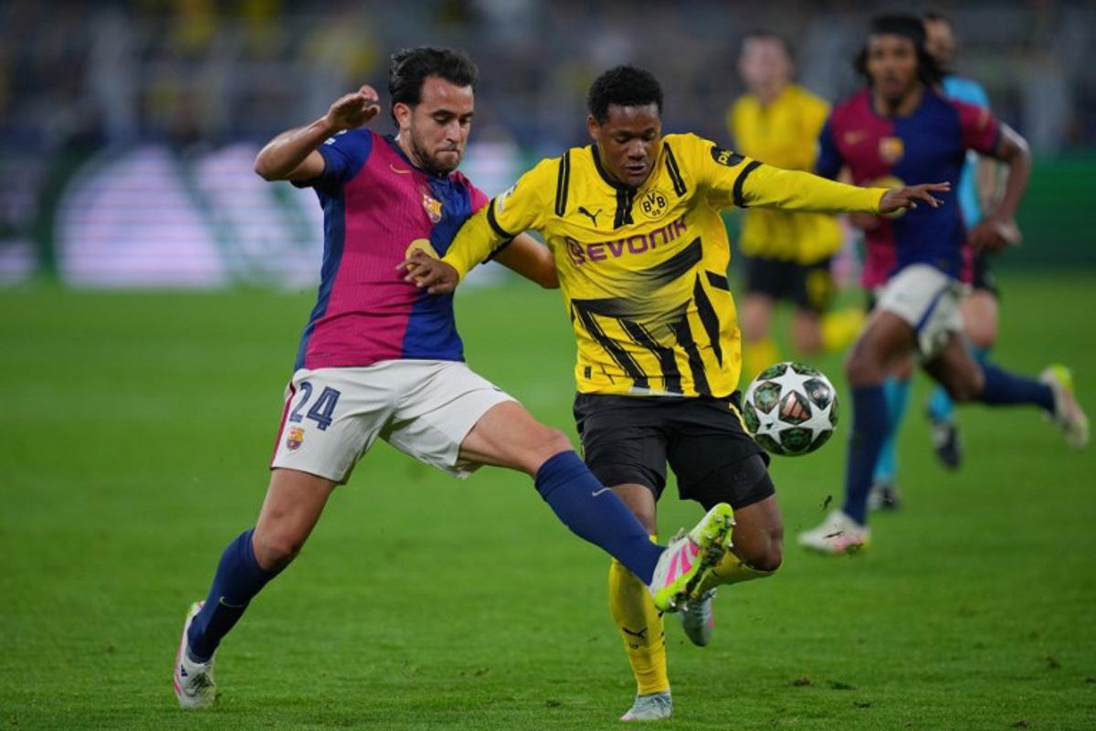Barcelona's Spanish defender #24 Eric Garcia (L)and Dortmund's Belgian forward #16 Julien Duranville vie for the ball during the UEFA Champions League quarter-final second leg football match between BVB Borussia Dortmund and FC Barcelona in Dortmund, western Germany on April 15, 2025.  Pau BARRENA / AFP