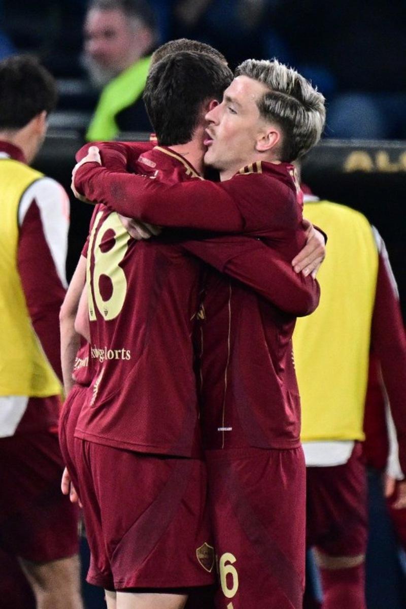 Roma's Argentine forward #18 Matias Soule celebrates with teammate Roma's Belgian forward #56 Alexis Saelemaekers (R) after scoring his team's first goal during the Italian Serie A football match between Lazio and Roma at the Olympic Stadium in Rome on April 13, 2025.  Tiziana FABI / AFP