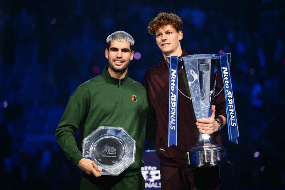 Italy's Jannik Sinner (R) and Spain's Carlos Alcaraz pose with their trophies at the end of the men's single final match at the ATP Finals tennis tournament, in Turin, on November 16, 2025.  Marco BERTORELLO / AFP