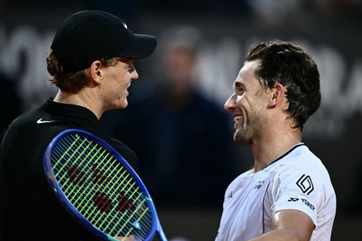 Italy's Jannik Sinner (l) celebrates at the end of his men's singles quarter-final match against Norway's Casper Ruud (r) for the ATP Rome Open tennis tournament at Foro Italico in Rome on May 15, 2025.   Filippo MONTEFORTE / AFP