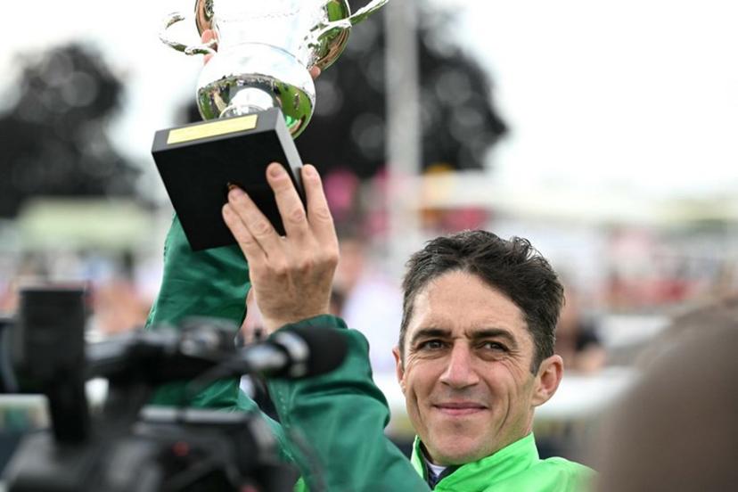 Belgium's Christophe Soumillon riding "Gezora" holds the trophy after winning the Diane Longines prize horse race at the Chantilly race course, north of Paris, on June 15, 2025.  Hugo MATHY / AFP