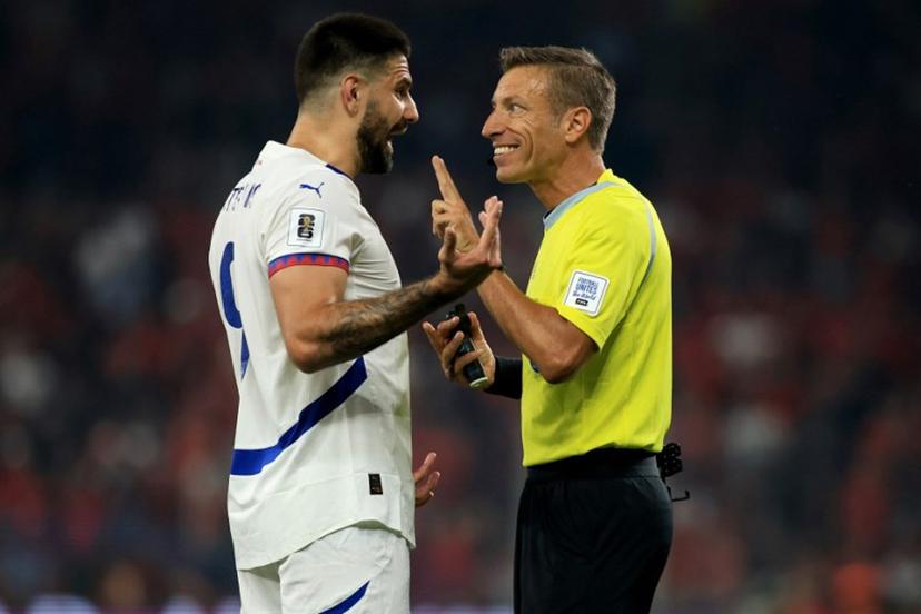 Serbia's forward #09 Aleksandar Mitrovic (L) talks to Italian referee Davide Massa during the 2026 World Cup qualifiers Europe zone, 1st round group K football match between Albania and Serbia at the Air Albania Stadium in Tirana on June 7, 2025.  Adnan Beci / AFP