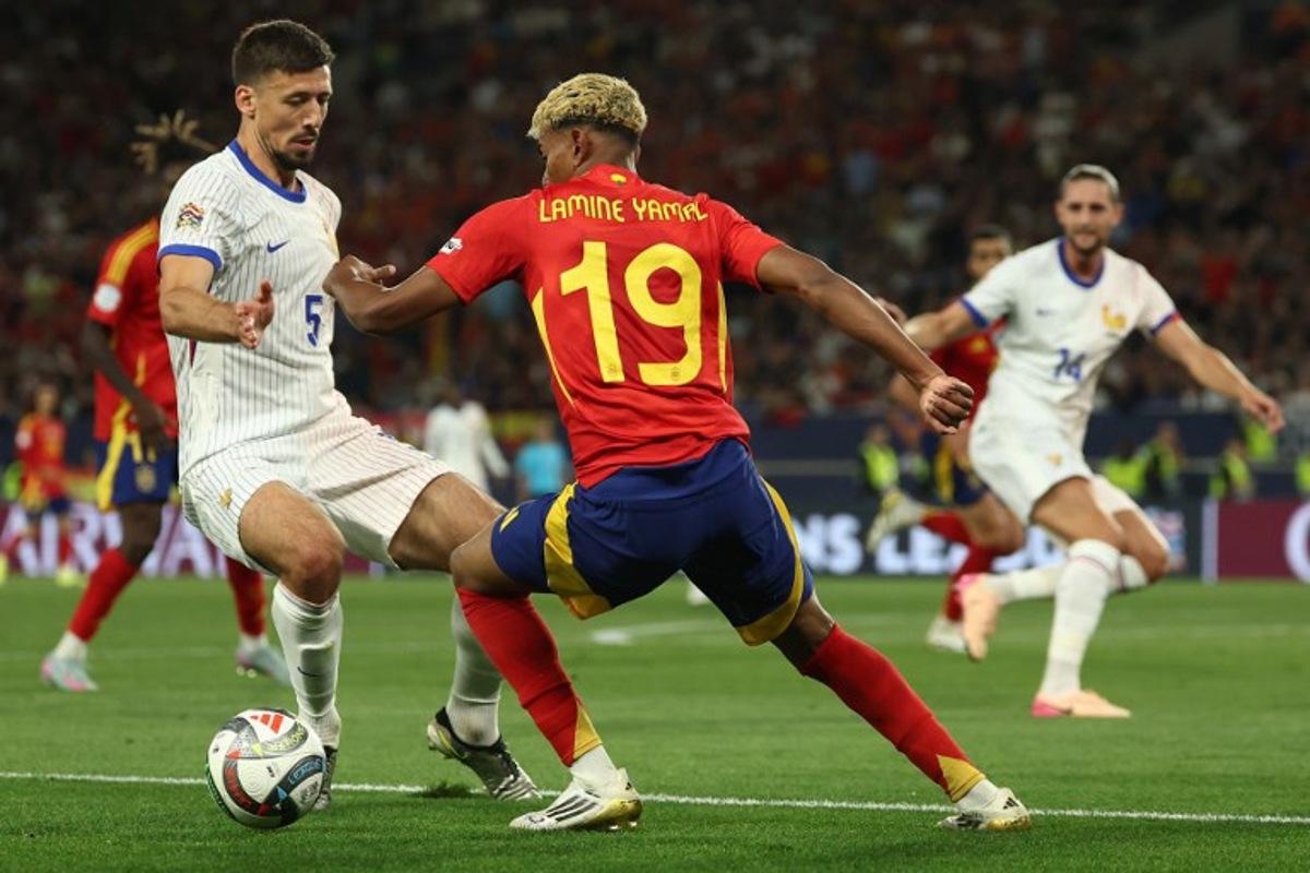 Spain's forward #19 Lamine Yamal (C) and France's defender #05 Clement Lenglet vie for the ball during the UEFA Nations League semi-final football match between Spain and France in Stuttgart, southwestern Germany, on June 5, 2025.  FRANCK FIFE / AFP