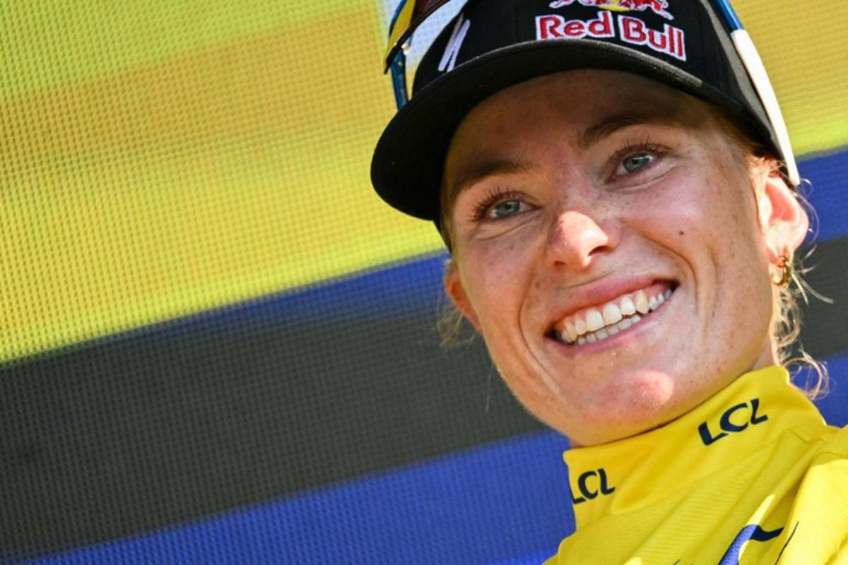 FDJ-SUEZ's Dutch rider Demi Vollering celebrates on the podium wearing the overall leader's yellow jersey after the 8th (out of 9) stage of the fifth edition of the Women's Tour de France cycling race, 171.9 km from Sisteron to Nice, in Nice, southeastern France on August 8, 2026.  NICOLAS TUCAT / AFP