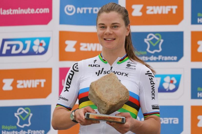 Team SD Worx - Protime's Belgian rider Lotte Kopecky celebrates on the podium with the cobblestone trophy after winning the fourth edition of the women's Paris-Roubaix one-day classic cycling race, 148,5km between Denain and Roubaix, on April 6, 2024.  Thomas SAMSON / AFP