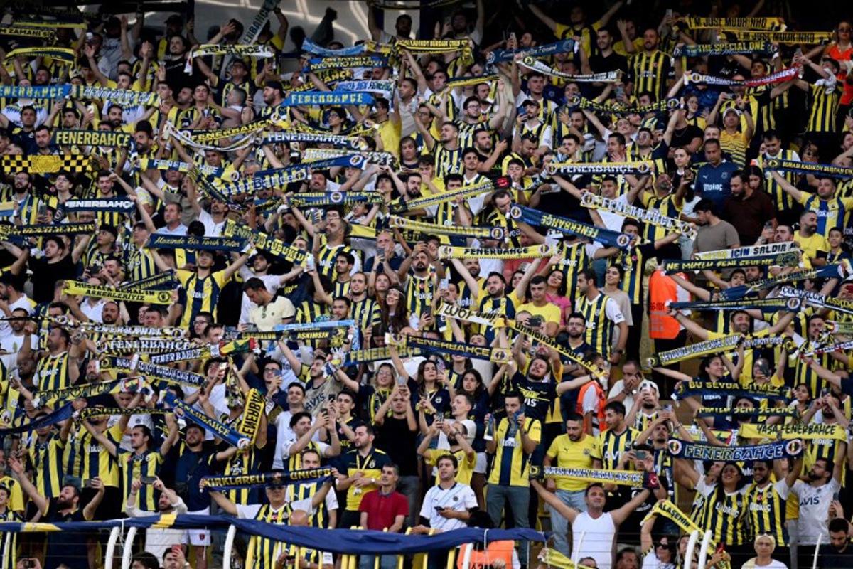 Fenerbahce's fans cheer during the UEFA Champions League 3rd Qualifying Round second leg football match between Fenerbahce and Lille LOSC at the Fenerbahçe Sükrü Saracoğlu Stadium in Istanbul on August 13, 2024.  Ozan KOSE / AFP