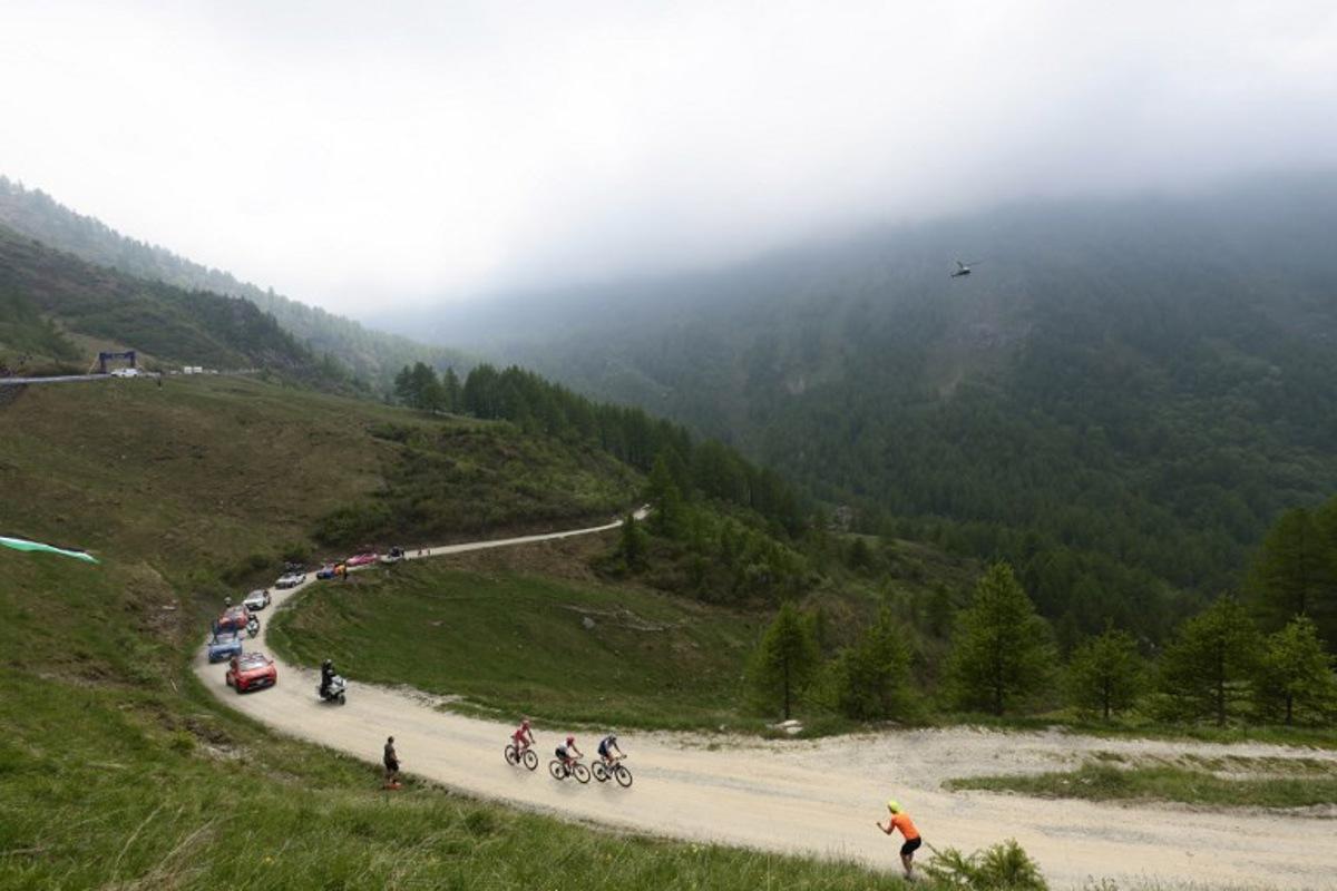 Spectators watch as riders cycle on the ascent of the Colle Delle Finestre during the 20th stage of the 108th Giro d'Italia cycling race 205kms from Verres to Sestriere on May 31, 2025.  Luca Bettini / AFP