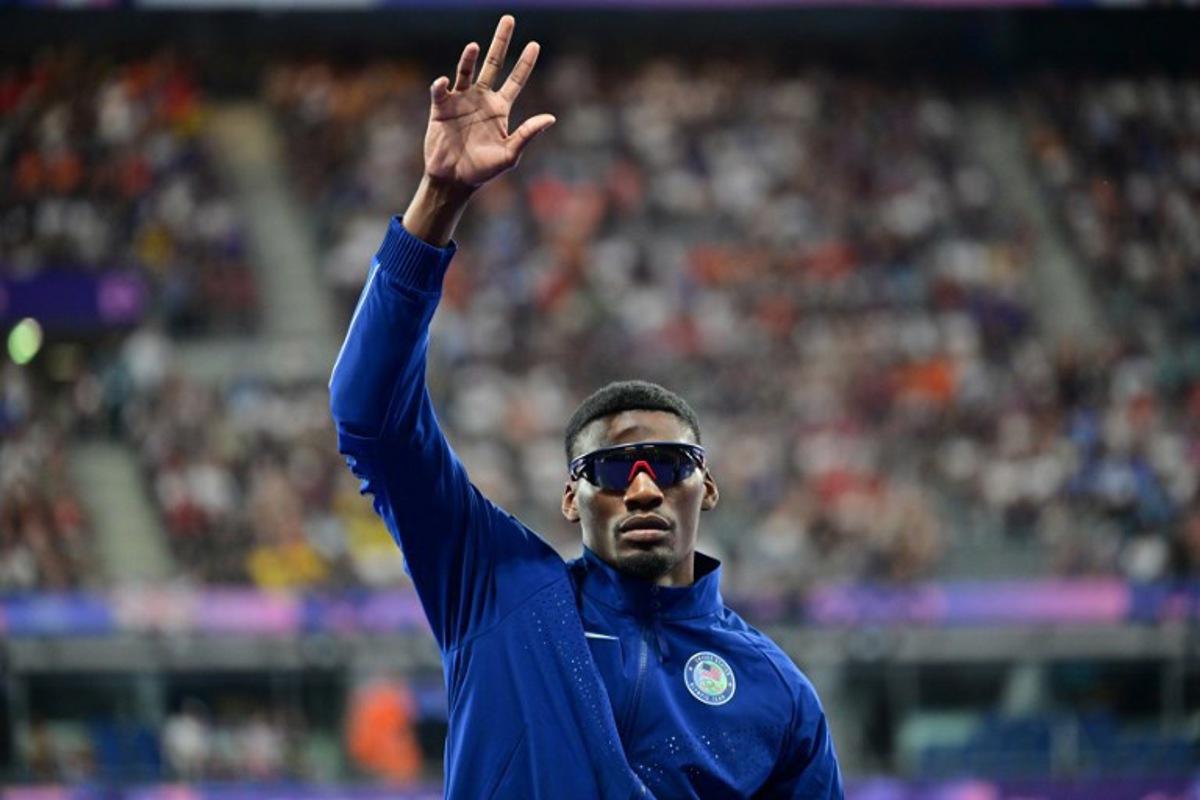 Bronze medallist US' Fred Kerley celebrates on the podium during the victory ceremony for the men's 100m athletics event during the Paris 2024 Olympic Games at Stade de France in Saint-Denis, north of Paris, on August 5, 2024.  Martin  BERNETTI / AFP