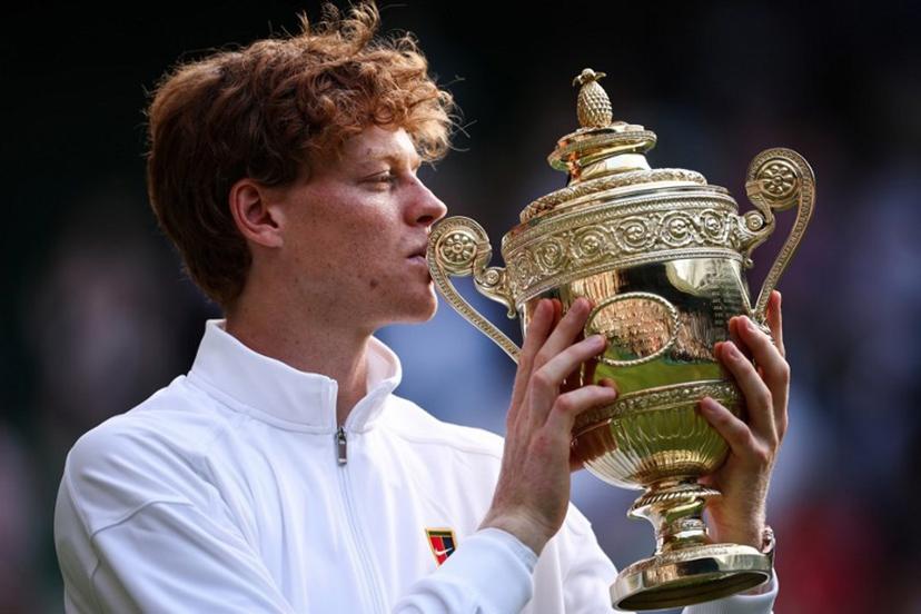 Italy's Jannik Sinner kisses the winner's trophy as he poses for pictures following his victory against Spain's Carlos Alcaraz at the end of their men's singles final tennis match on the fourteenth day of the 2025 Wimbledon Championships at The All England Lawn Tennis and Croquet Club in Wimbledon, southwest London, on July 13, 2025.  HENRY NICHOLLS / AFP