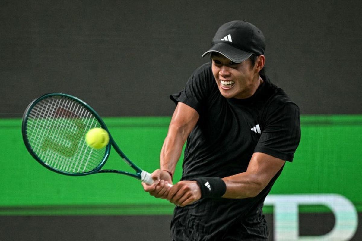 United States's Learner Tien hits a return to Russia's Daniil Medvedev during their men's singles match at the Shanghai Masters tennis tournament in Shanghai on October 8, 2025.  HECTOR RETAMAL / AFP