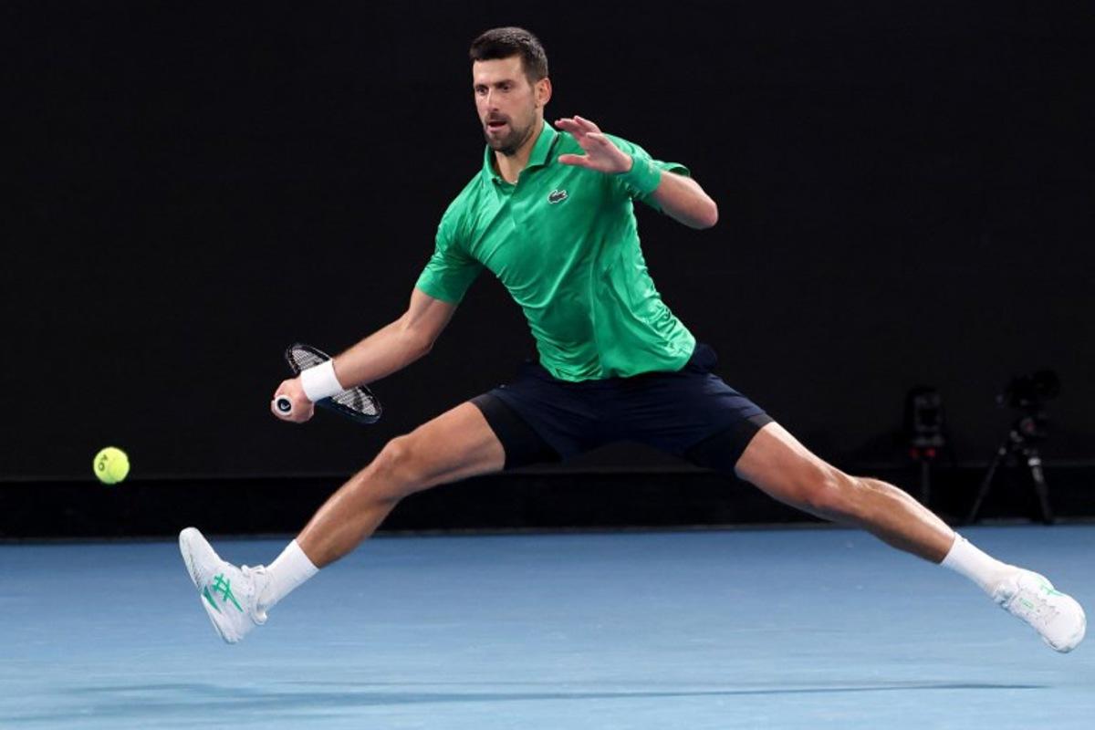 Serbia's Novak Djokovic hits a return to Spain's Pedro Martinez during their men's singles match on day two of the Australian Open tennis tournament in Melbourne on January 19, 2026.  DAVID GRAY / AFP