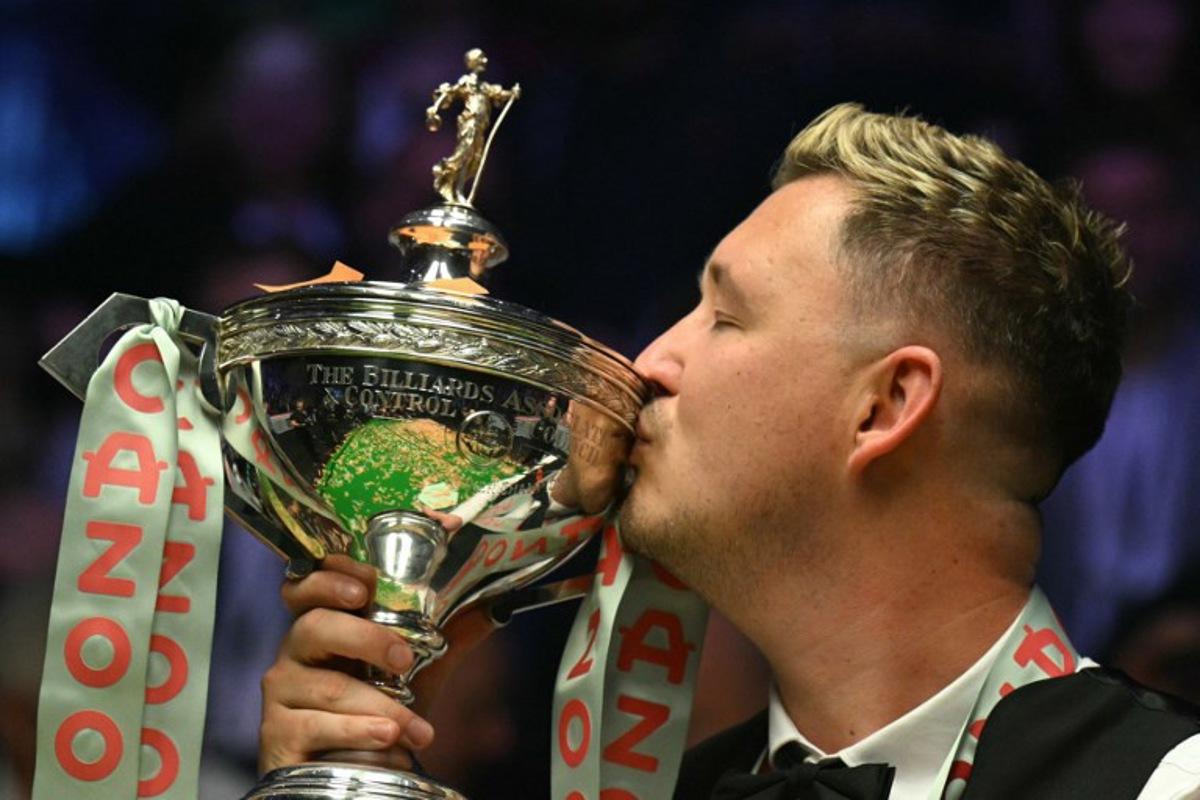 England's Kyren Wilson kisses the trophy after victory over Wales' Jak Jones on day two of their World Championship Snooker final at The Crucible in Sheffield, northern England on May 6, 2024.  Wilson won the final 18-14. Oli SCARFF / AFP