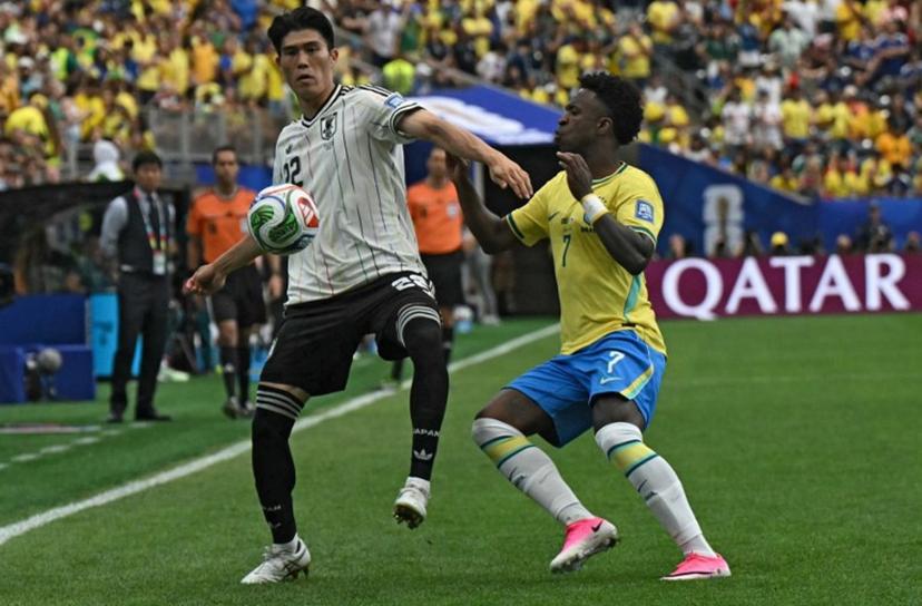Japan's defender #22 Takehiro Tomiyasu (L) fights for the ball with Brazil's forward #07 Vinicius Junior during the 2026 World Cup round of 32 football match between Brazil and Japan at the Houston Stadium in Houston on June 29, 2026.   RONALDO SCHEMIDT / AFP