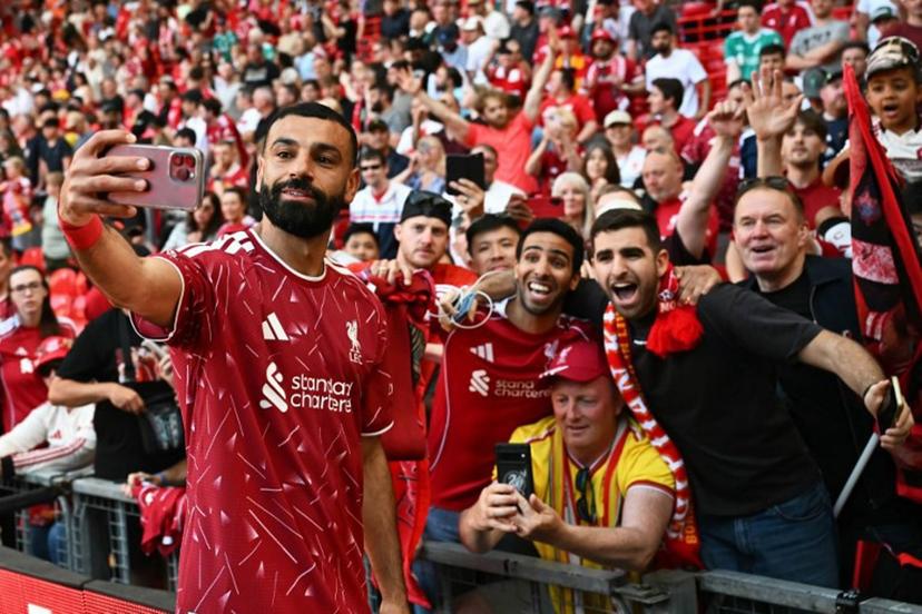 Liverpool's Egyptian striker #11 Mohamed Salah takes a selfie with fans after the English Premier League football match between Liverpool and Brentford at Anfield in Liverpool, north west England on May 24, 2026. Paul ELLIS / AFP