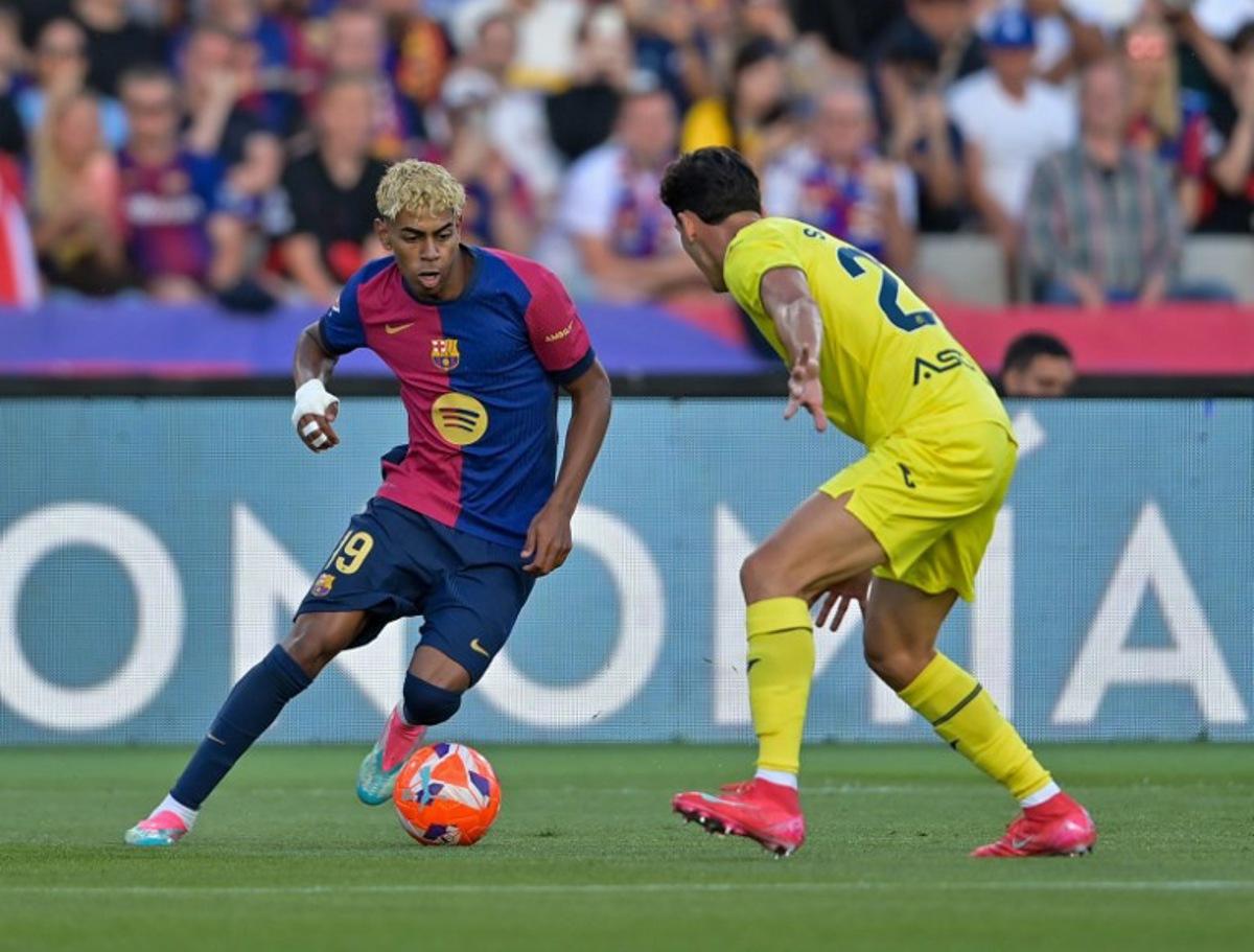 Villarreal's Spanish defender #23 Sergi Cardona (R) and Barcelona's Spanish forward #19 Lamine Yamal vie for the ball during the Spanish league football match between FC Barcelona and Villarreal CF at Estadi Olimpic Lluis Companys in Barcelona on May 18, 2025.  MANAURE QUINTERO / AFP