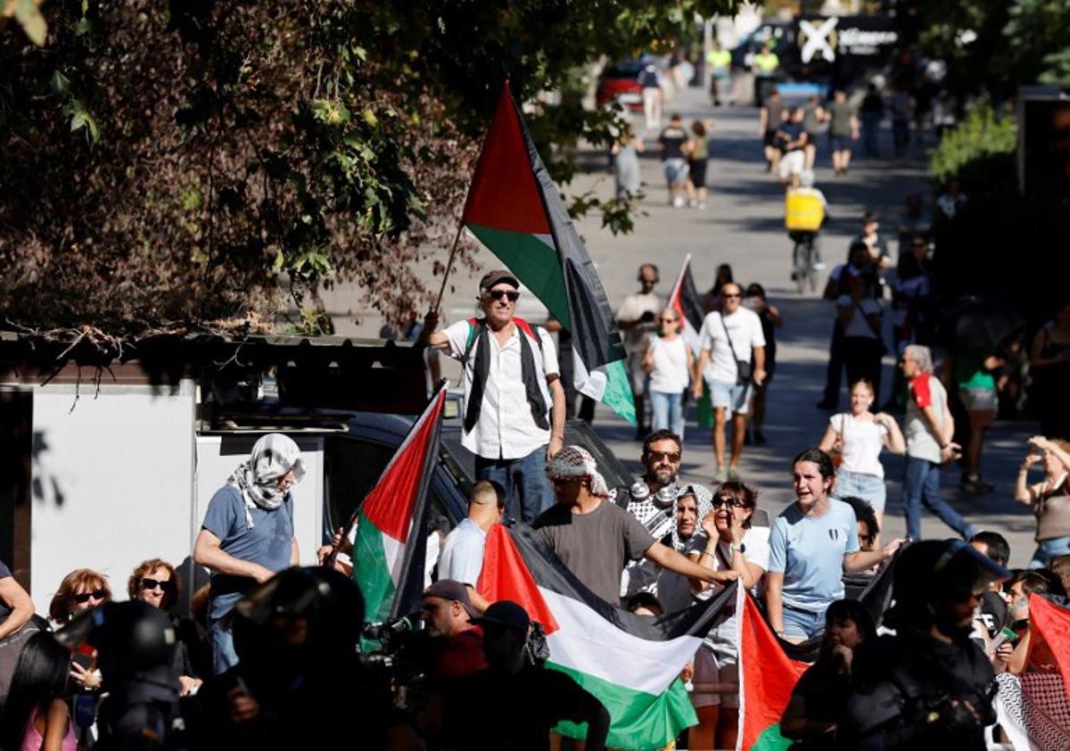 Pro-Palestinians protestors hold Palestinian flags during the 21st and last stage of the Vuelta a Espana 2025, a 101 km race between Alalpardo and Madrid, near Madrid's Atocha train station on September 14, 2025.   The authorities have ramped up security for the Vuelta's final stage in Madrid, which was slightly shortened and will see 1,100 police officers deploy in the Spanish capital. Pierre-Philippe MARCOU / AFP