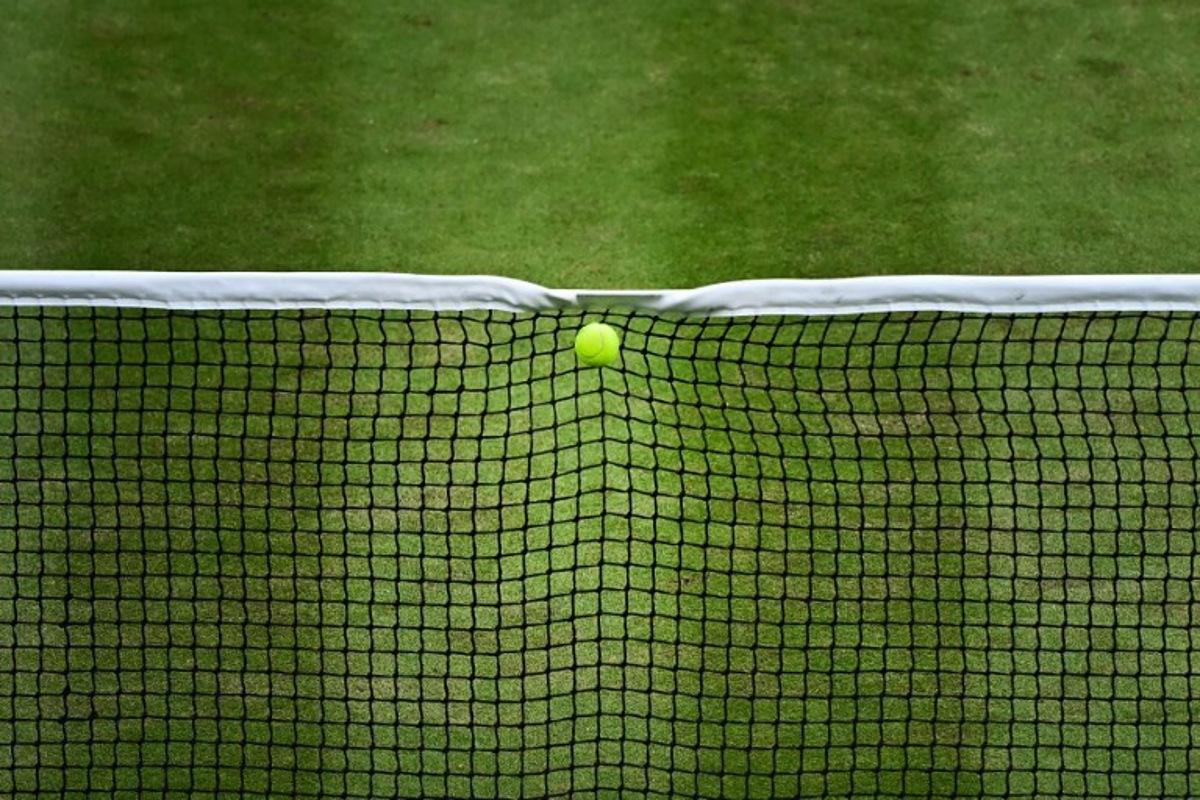 The ball served by Italy's Lorenzo Musetti hits the net during his men's singles quarter-finals tennis match against US player Taylor Fritz on the tenth day of the 2024 Wimbledon Championships at The All England Lawn Tennis and Croquet Club in Wimbledon, southwest London, on July 10, 2024.  Ben Stansall / AFP