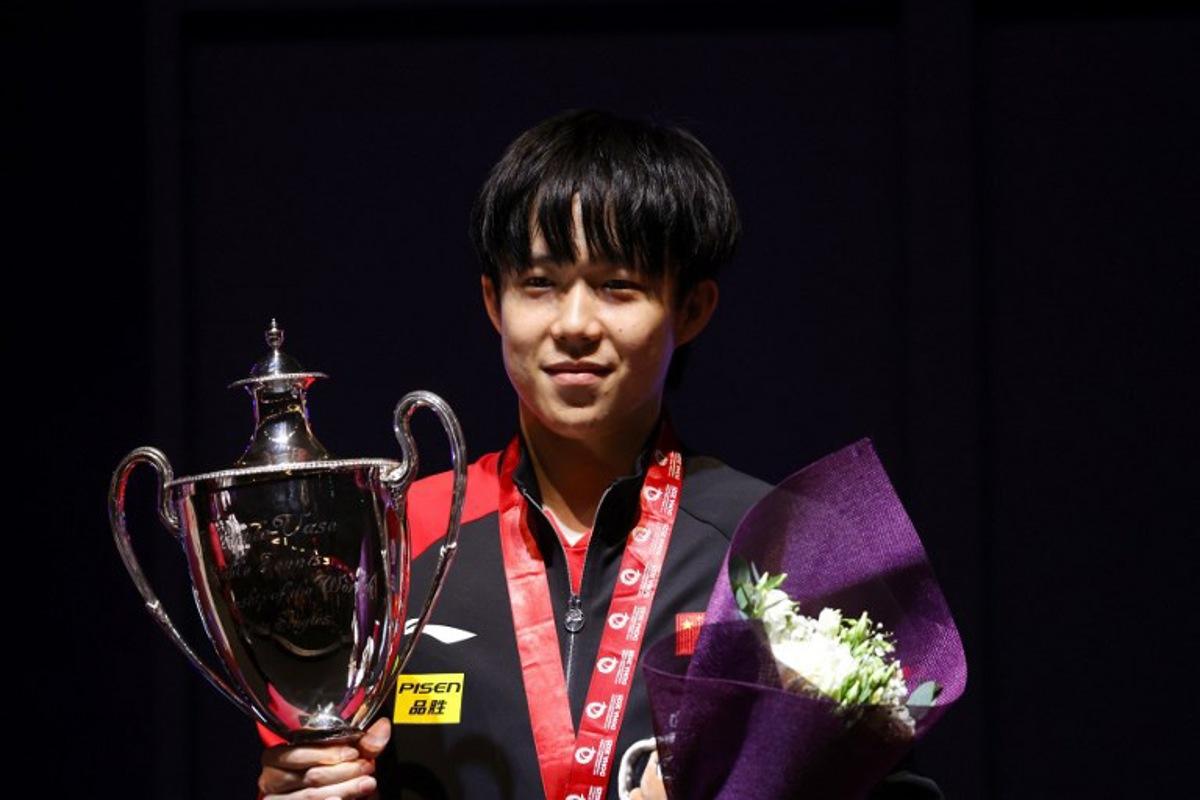 China's Wang Chuqin poses with his first-place trophy on the podium after the men's singles of the ITTF World Table Tennis Championship finals in Doha on May 25, 2025.  Karim JAAFAR / AFP