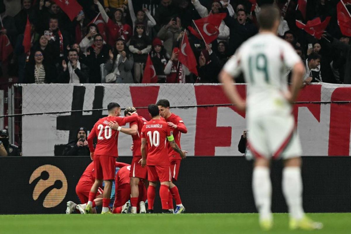 Turkey's midfielder #06 Orkun Kokcu celebrates with teammates after scoring his team's first goal during the UEFA Nations League playoff first-leg football match between Turkey and Hungary at the Rams Park Ali Samiyen Sport Complex Stadium in Istanbul on March 20, 2025.  OZAN KOSE / AFP